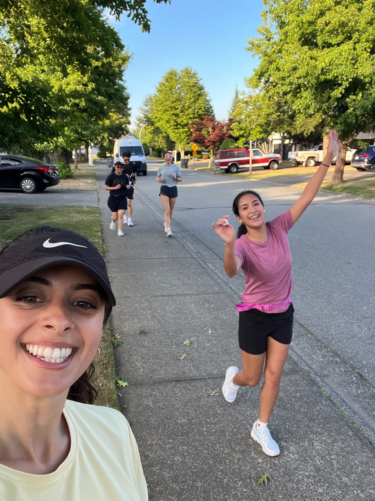A JoyRide runner on a sunny Surrey street, waving to the camera
