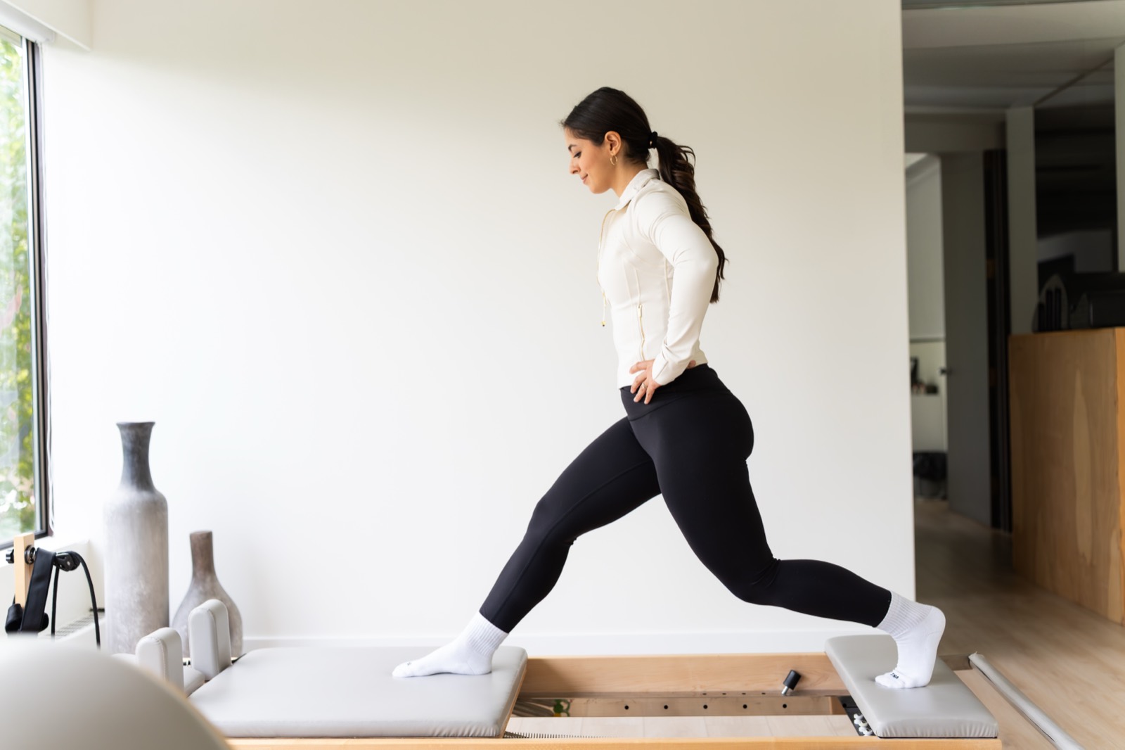 A client working through a lunge on the reformer in the Joybody studio