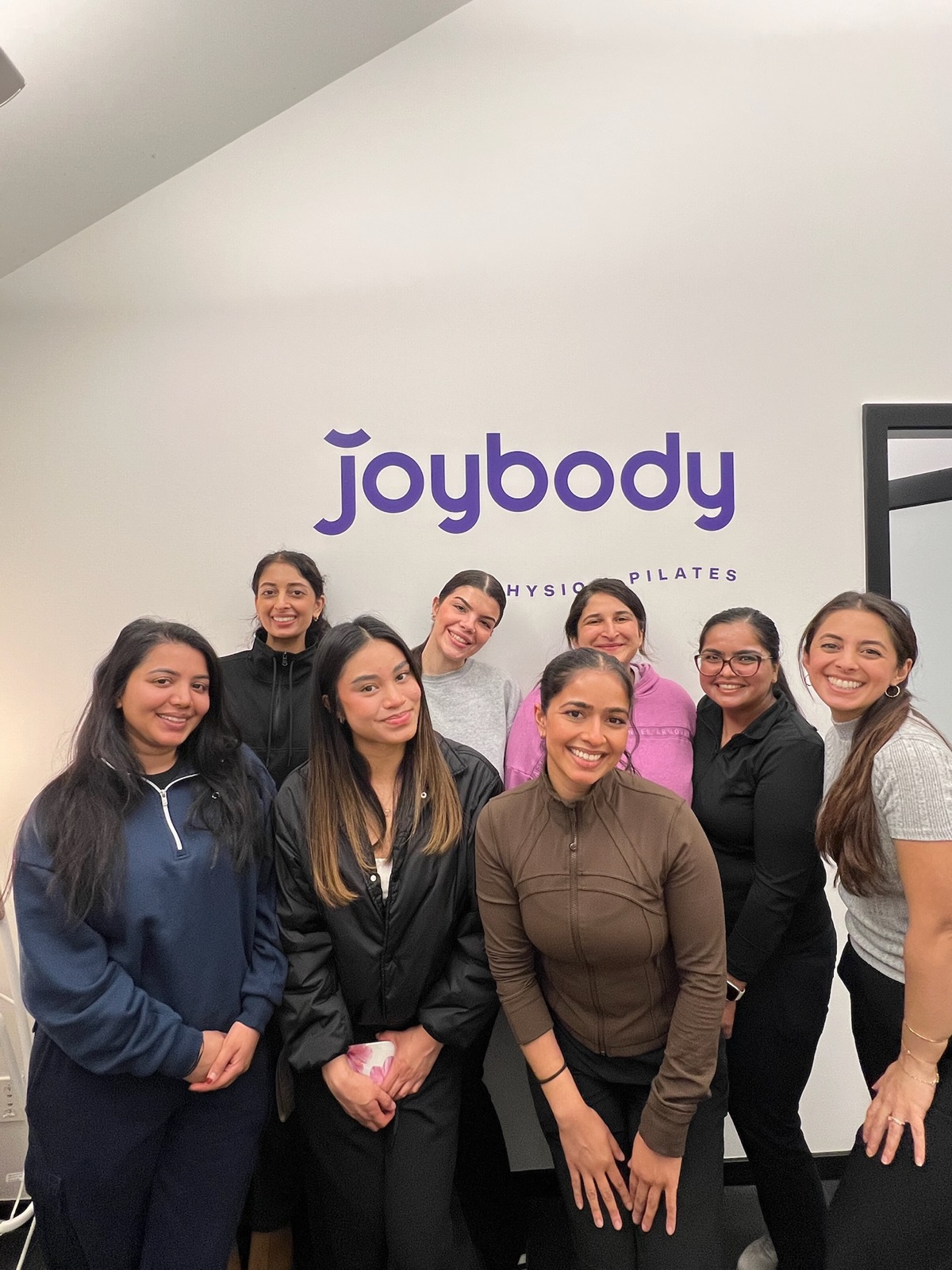 The Joybody team together in front of the studio wordmark